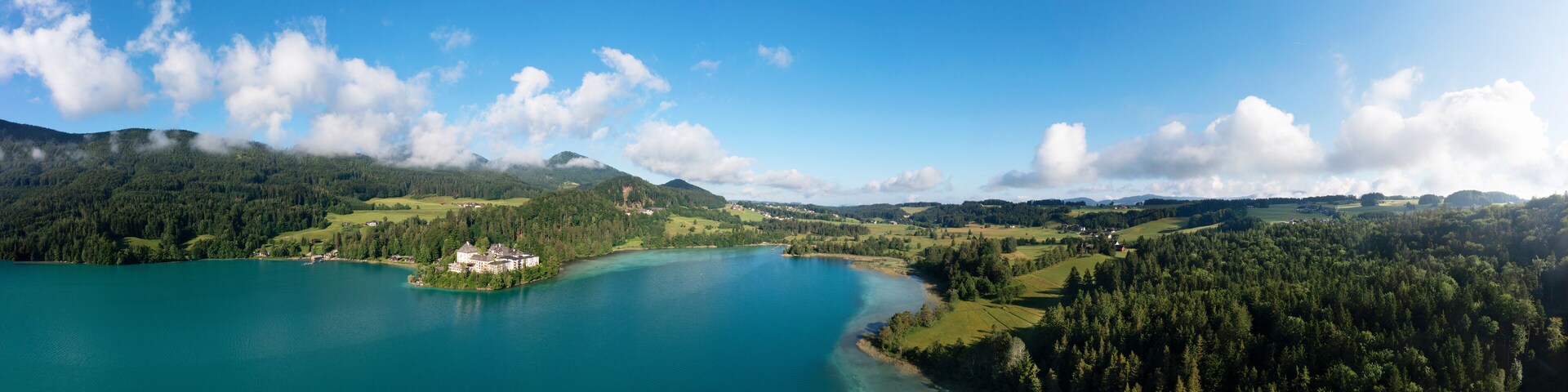 Austria, Salzburg, Hof bei Salzburg, Drone panorama of Lake Fuschl in summer with Schloss Fuschl in background