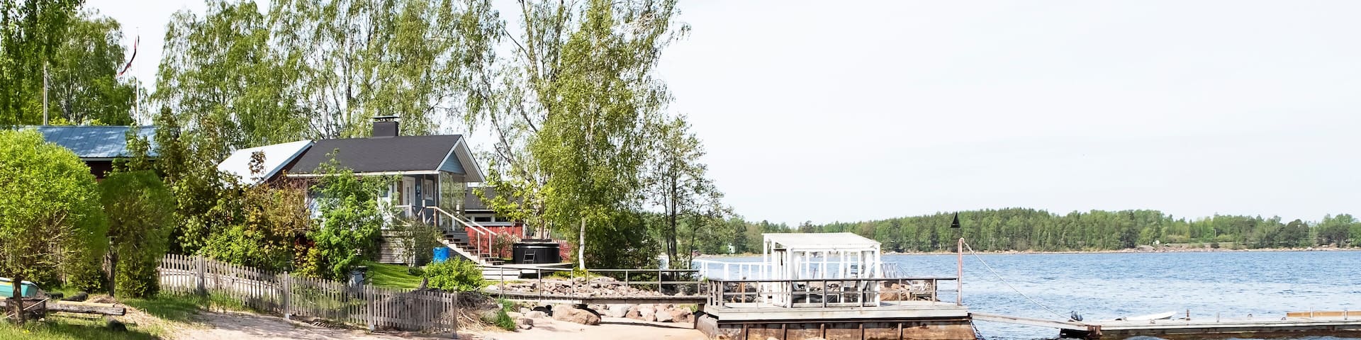 Sandy beach on the Baltic Sea in Finland. Summer houses and a pier in the city of Kotka.