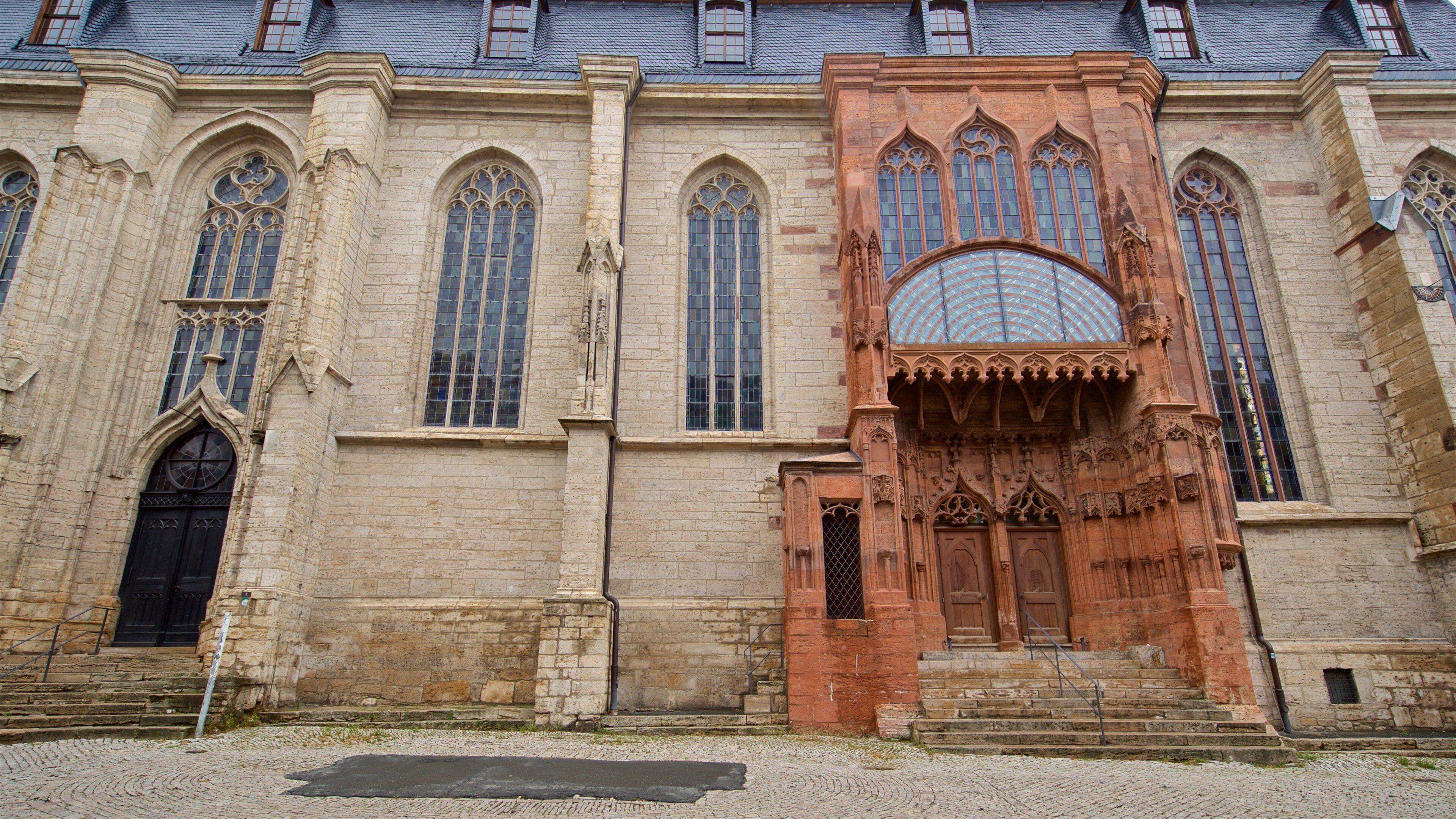 Un edificio histórico con amplias ventanas de arco y elaborados adornos de piedra.