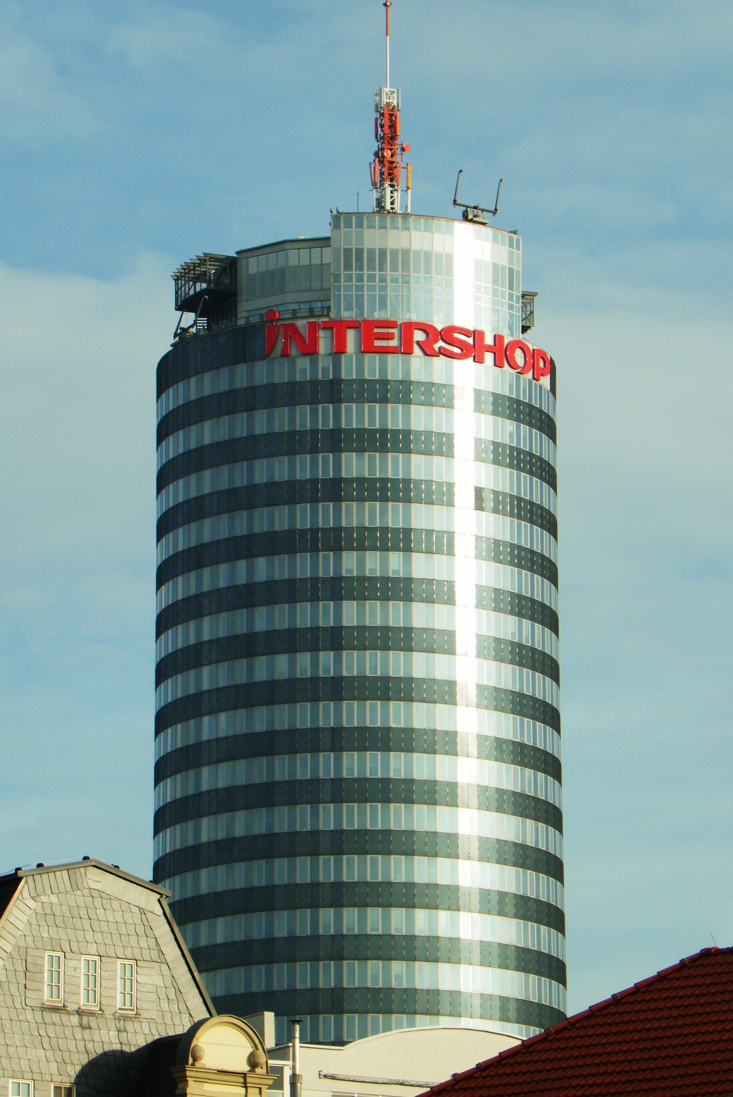 A tall, cylindrical building with the inscription "INTERSHOP" on its facade.