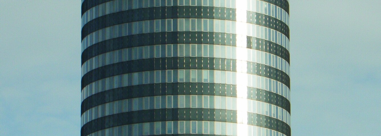 Um edifício alto e cilíndrico com a inscrição "INTERSHOP" na fachada.