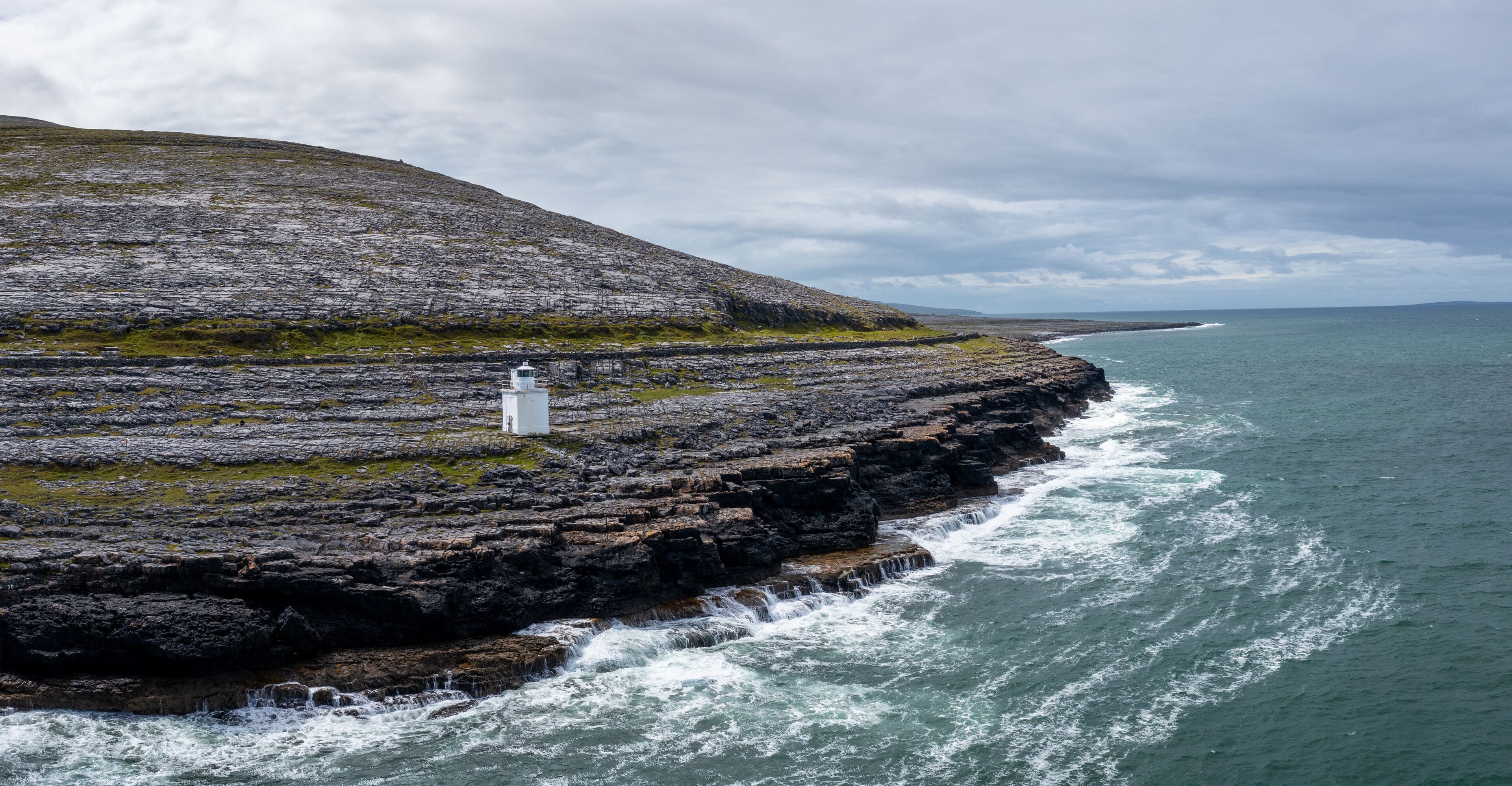 aerial view of the Burren Coast in County Clare with the Black Head Lighthouse on the rocky point