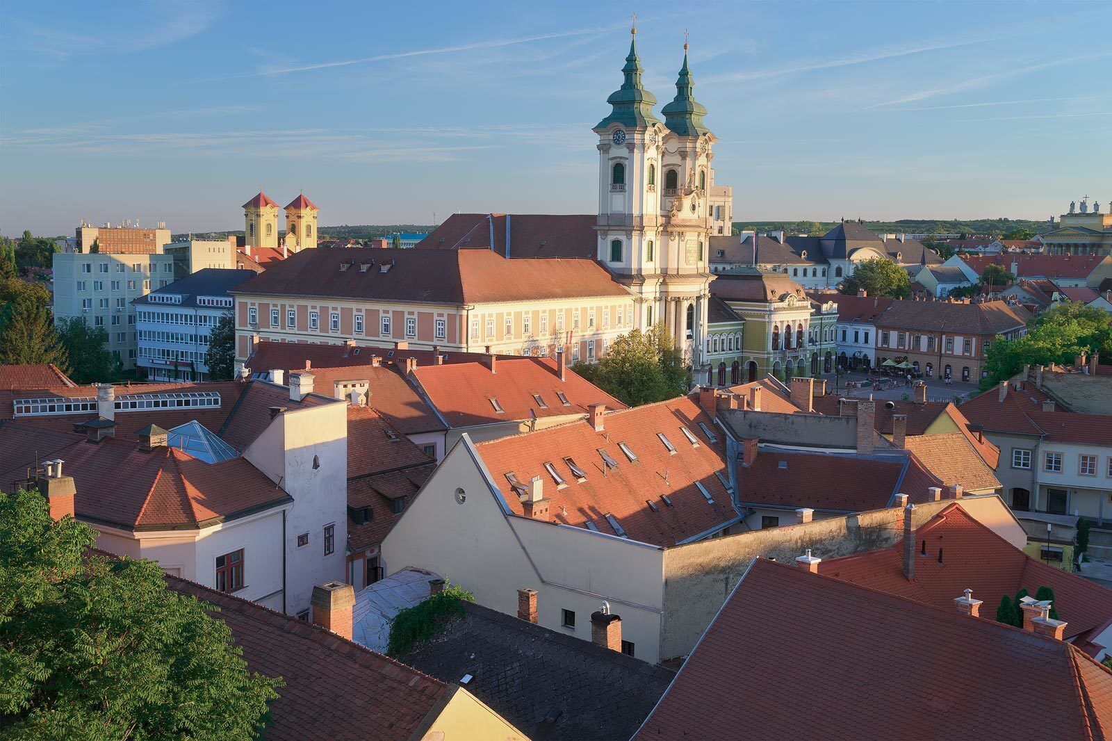 A historic town with a prominent church featuring twin spires and a central clock tower.