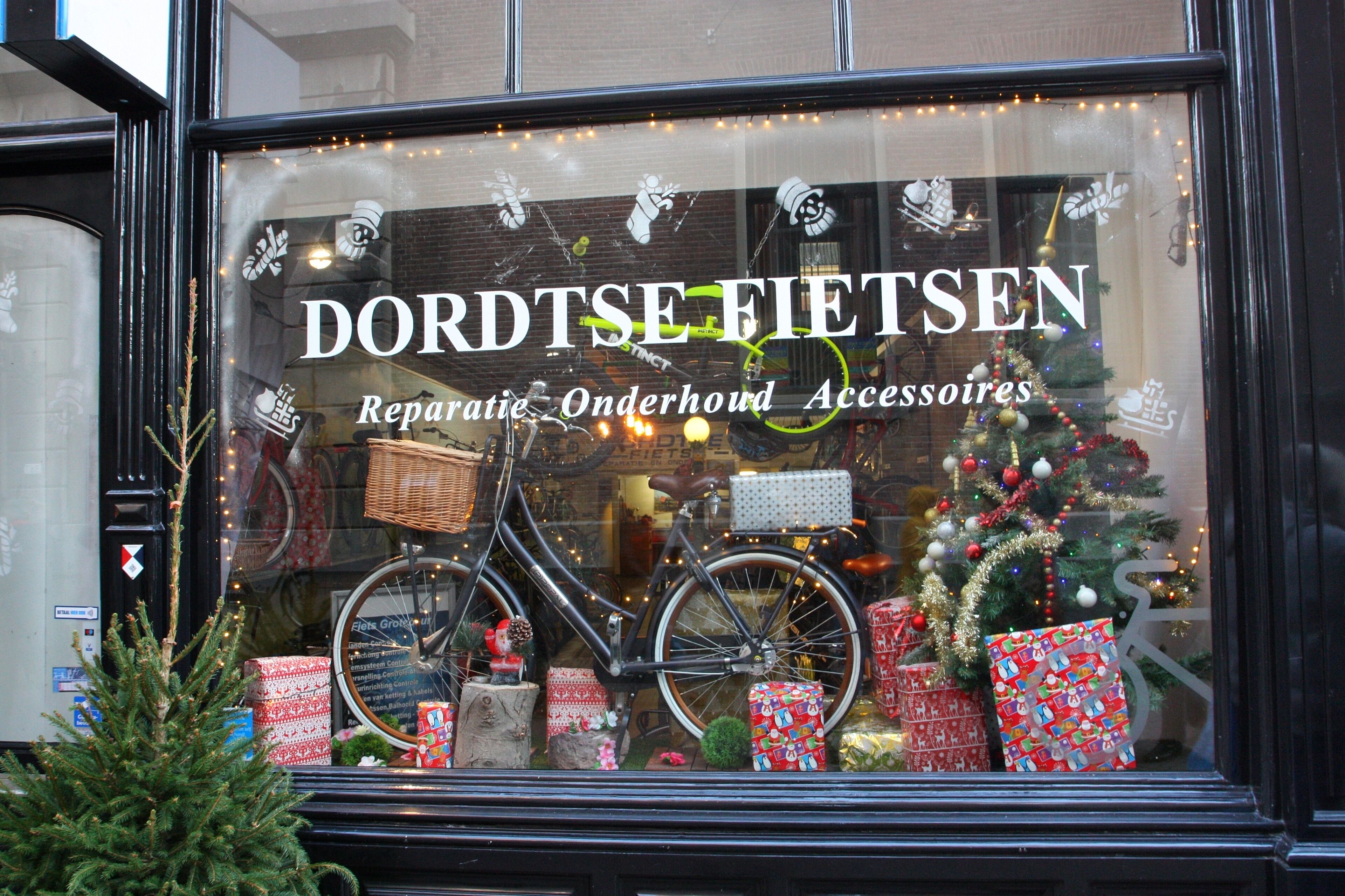 A bicycle in a shop window with Christmas decorations and presents.