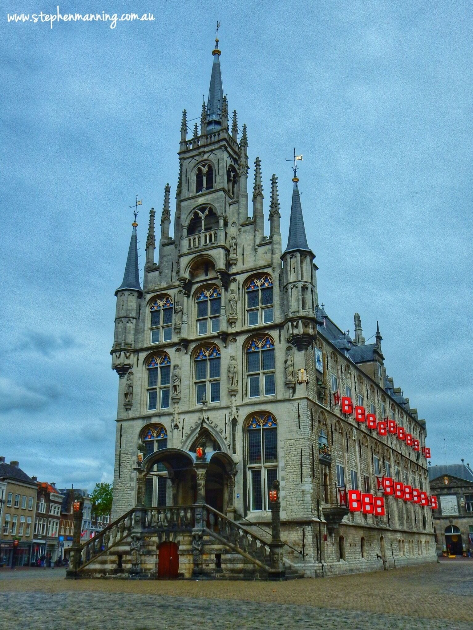 The word Stadhuis in Dutch means City Hall, however Stadhuis Gouda with it's gothic architecture,  stonework and spires could be easily mistaken for just another church. 

Built in 1450 it sits regally in the centre of Gouda's cobblestone paved market square and now houses the mayor's office, council chambers and function rooms that can be hired.

Many of the external windows have distinctive red wooden shutters and on the right facing wall is a carillon with mechanical puppets that move with the bells. The bells chime with a very unique clear quality for 2 minutes after the full and half hour.