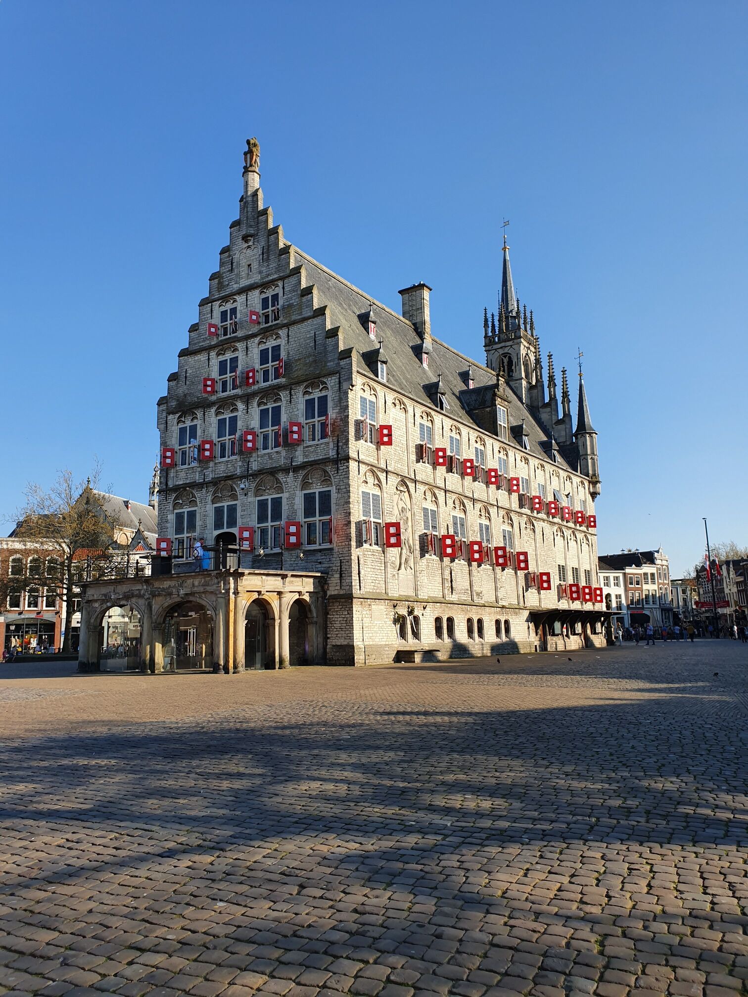 A historic building with a steeply pitched roof and multiple windows, surrounded by cobblestone streets.