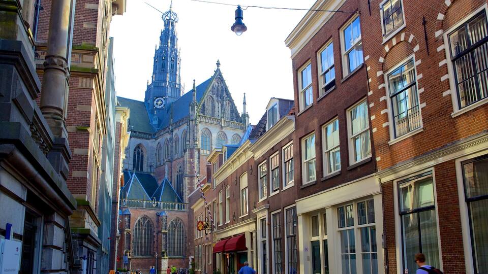 A street with historic buildings and a church with a tall spire.