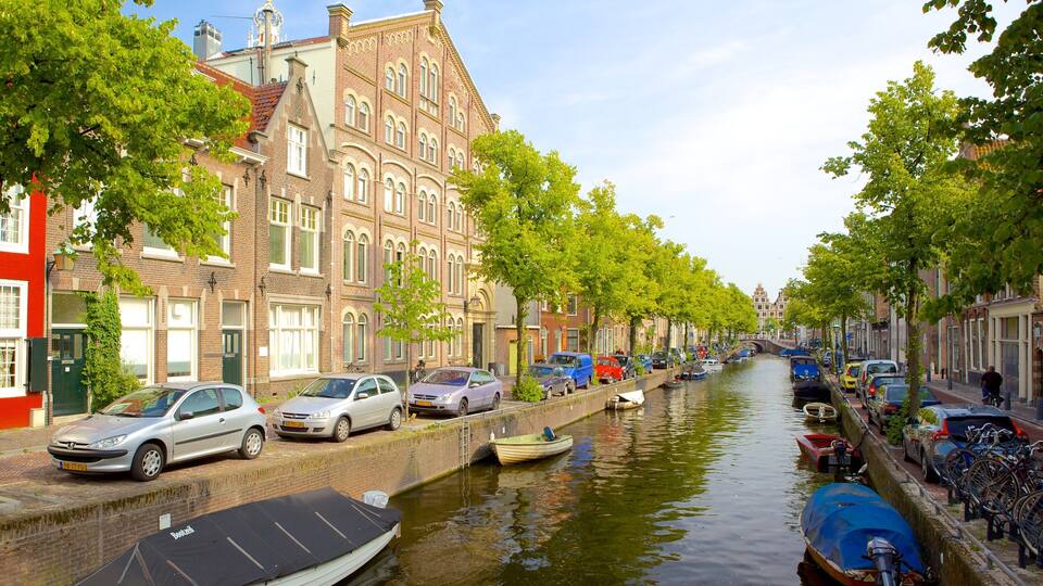 A canal lined with historic buildings and parked cars.