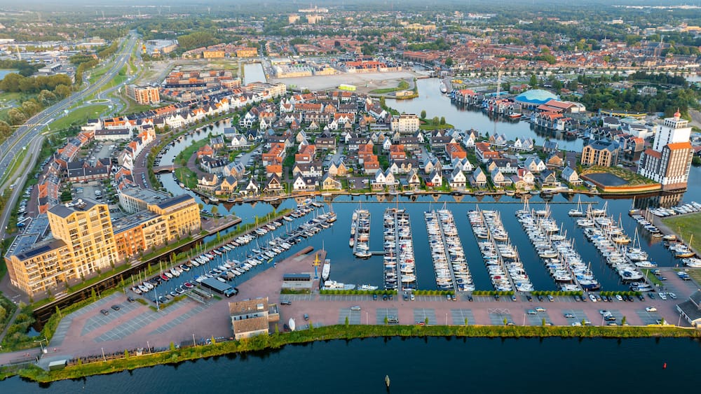 Une ville riveraine dotĂ©e dâun port de plaisance, de bĂątiments historiques et dâun pont moderne.
