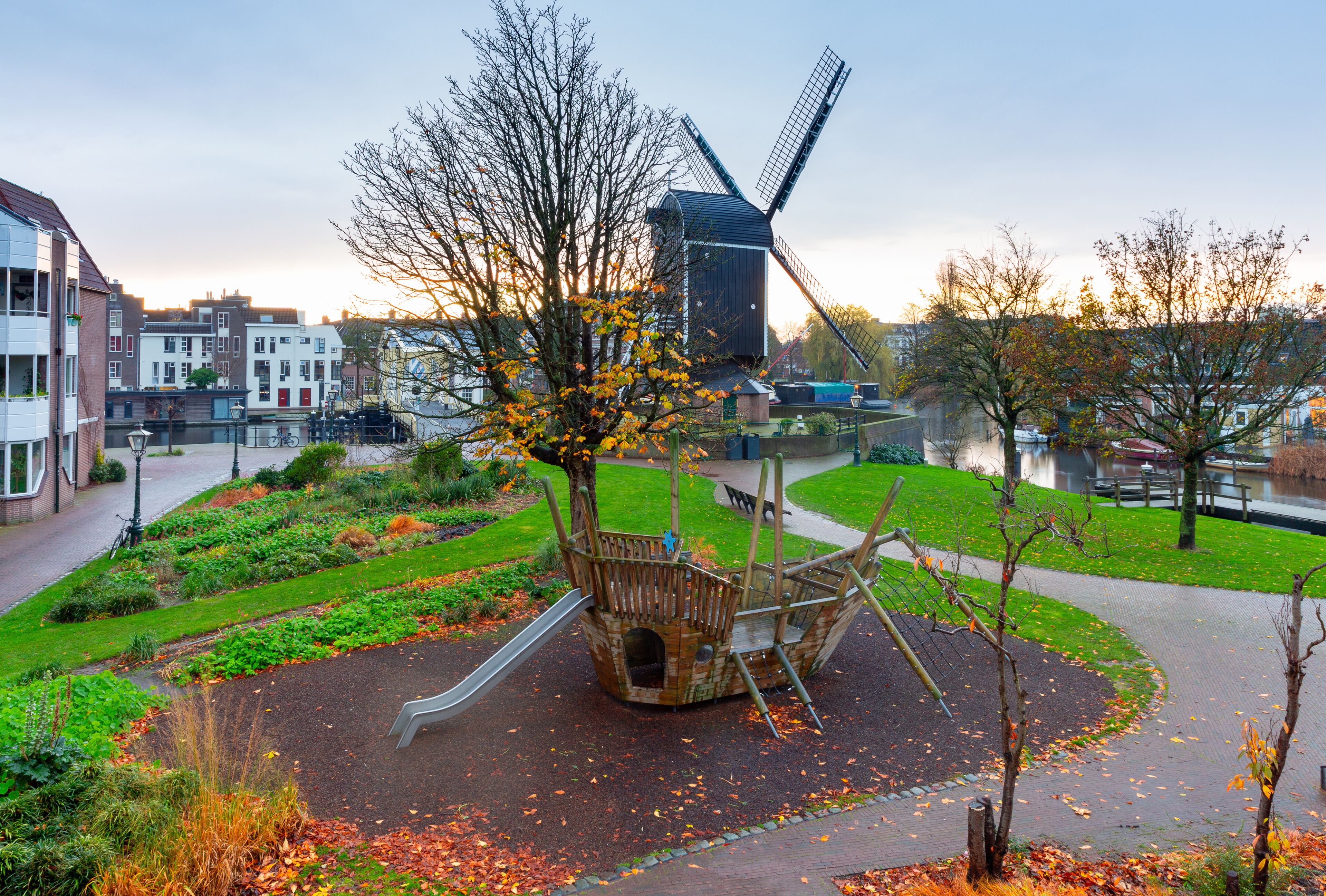 An old wooden mill on the banks of a canal in Leiden at dawn.