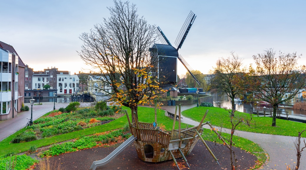 An old wooden mill on the banks of a canal in Leiden at dawn.