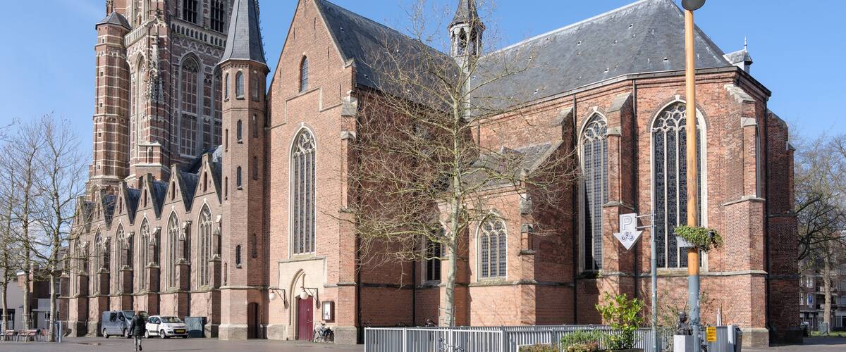 A historic church with a tall tower and a smaller adjacent building.