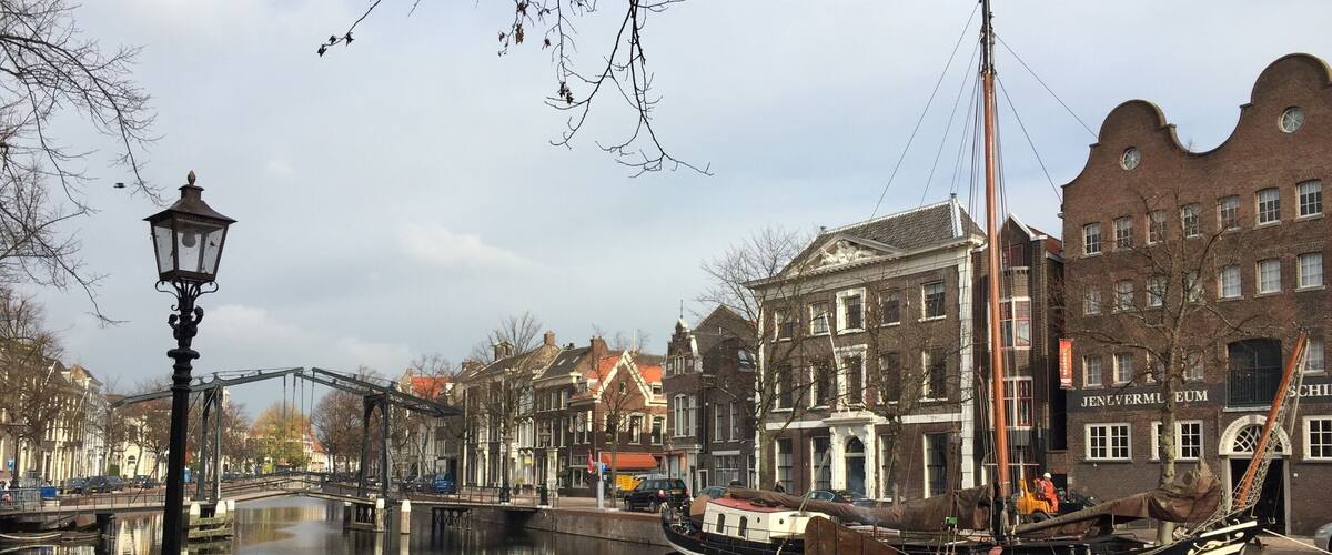 A canal with boats, a bridge, and historic buildings along the water's edge.