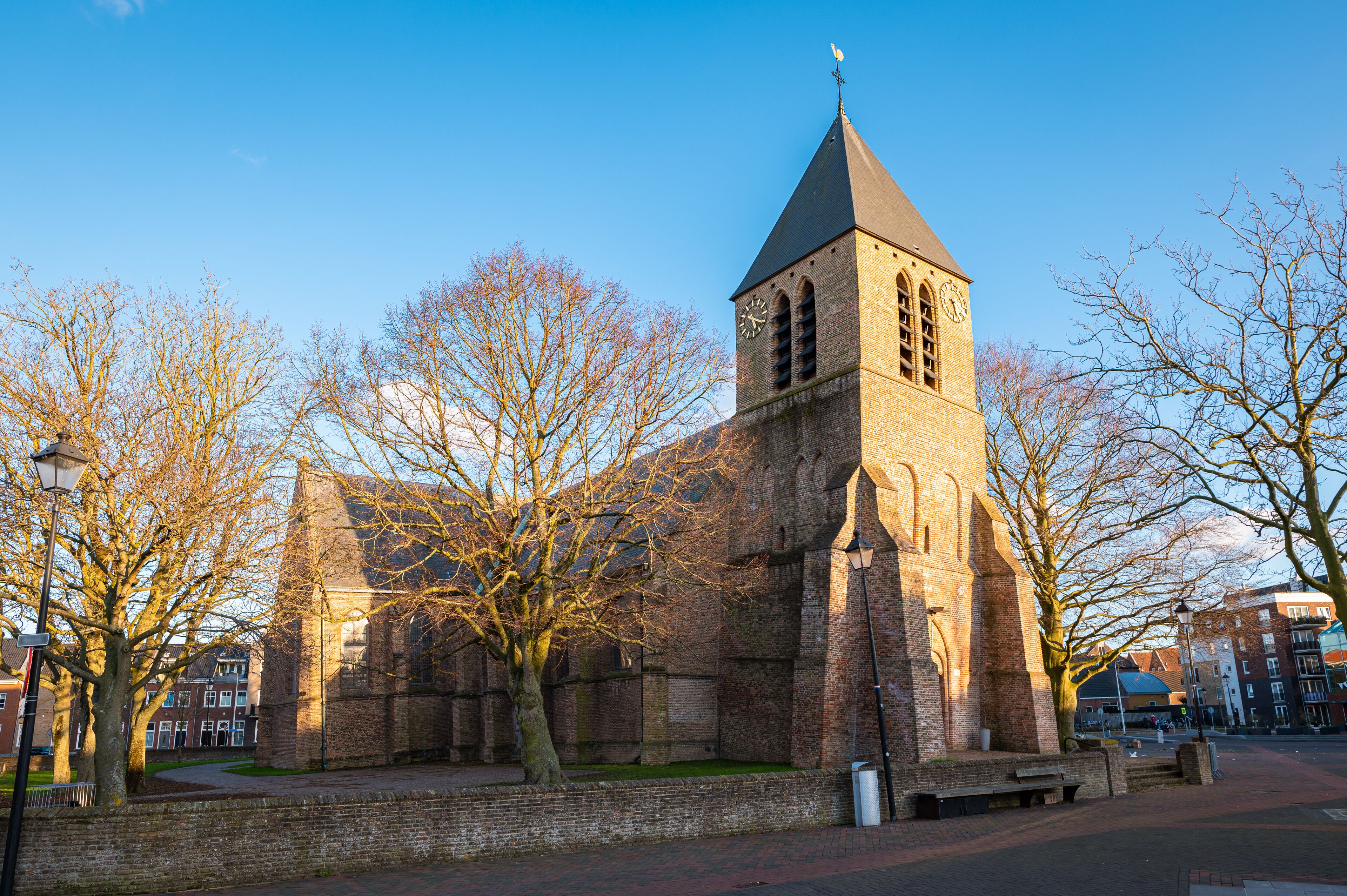 A historic church with a tall tower and a weather vane.