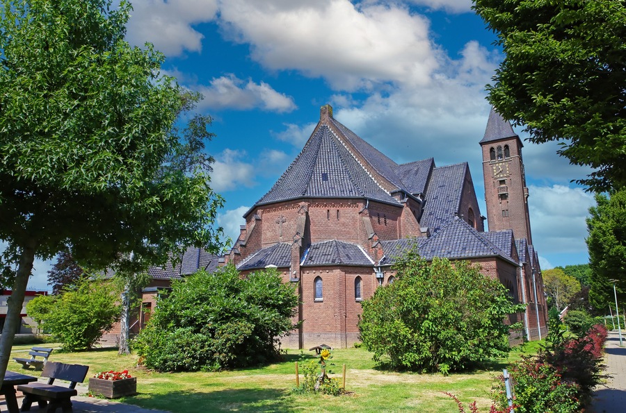 Beautiful neo gothic medieval St. Rochus church, green garden trees, now in use as Limburg archery museum - Steyl, Netherlands
