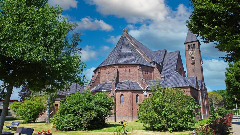 Beautiful neo gothic medieval St. Rochus church, green garden trees, now in use as Limburg archery museum - Steyl, Netherlands
