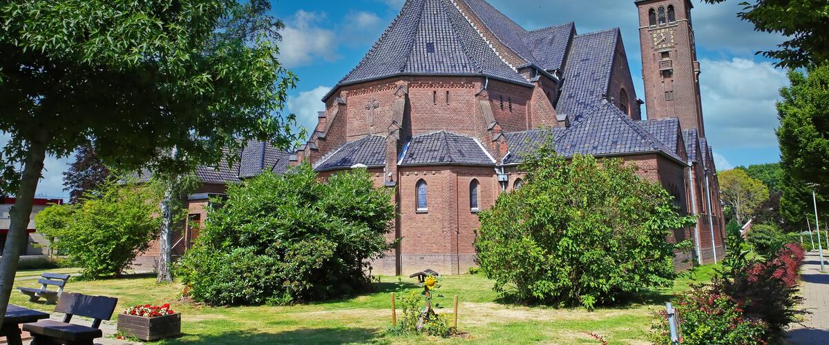 A historic church with a tall bell tower and a steeply pitched roof.