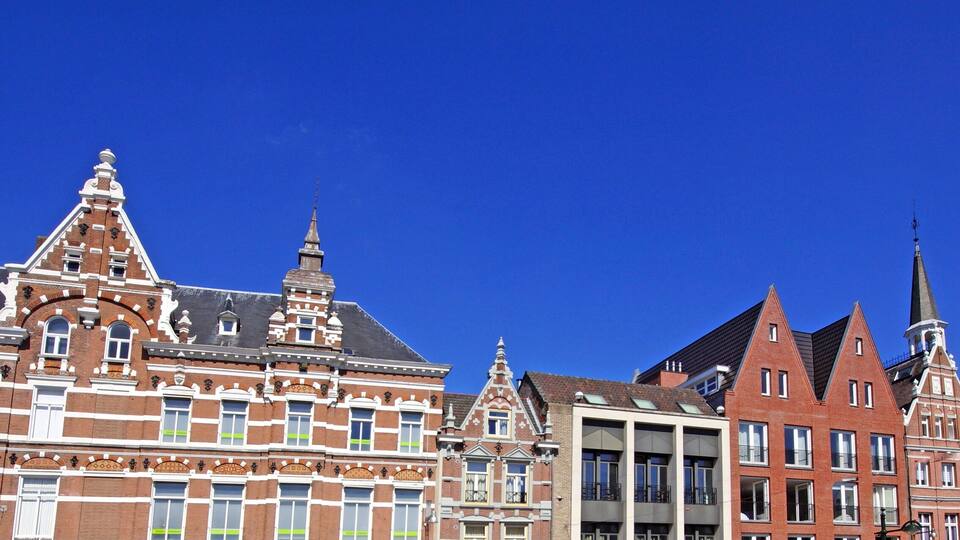 A row of historic buildings with intricate facades and multiple spires.