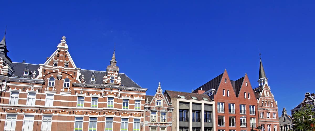 A row of historic buildings with intricate facades and multiple spires.