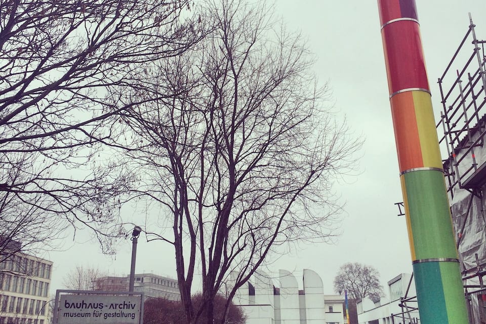Señal del museo Bauhaus-Ahrdorf dedicado al diseño, un árbol y un poste colorido.
