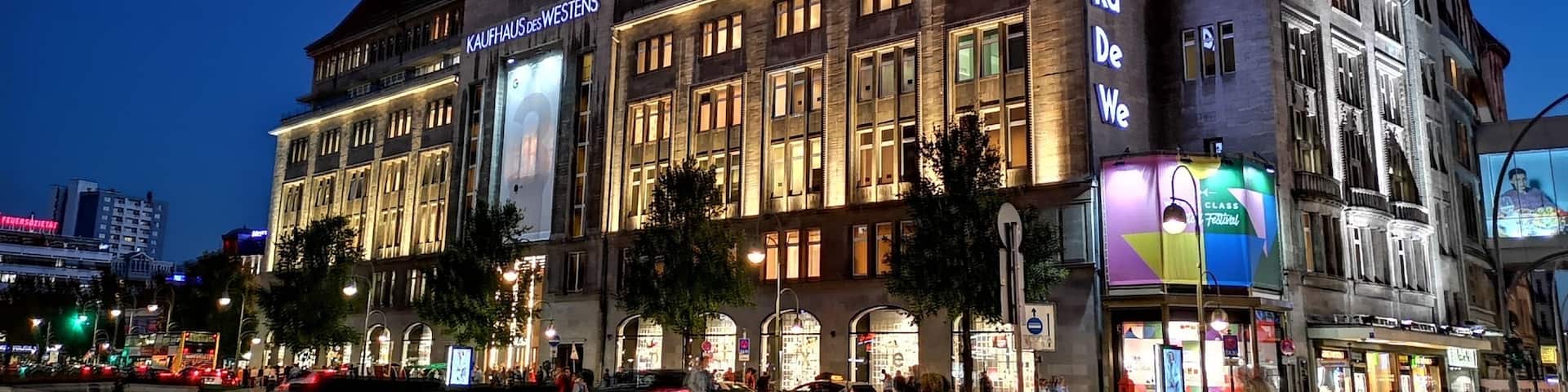 A historic building with illuminated signage, including "Kaufhaus des Westens" and "Ka De We."
