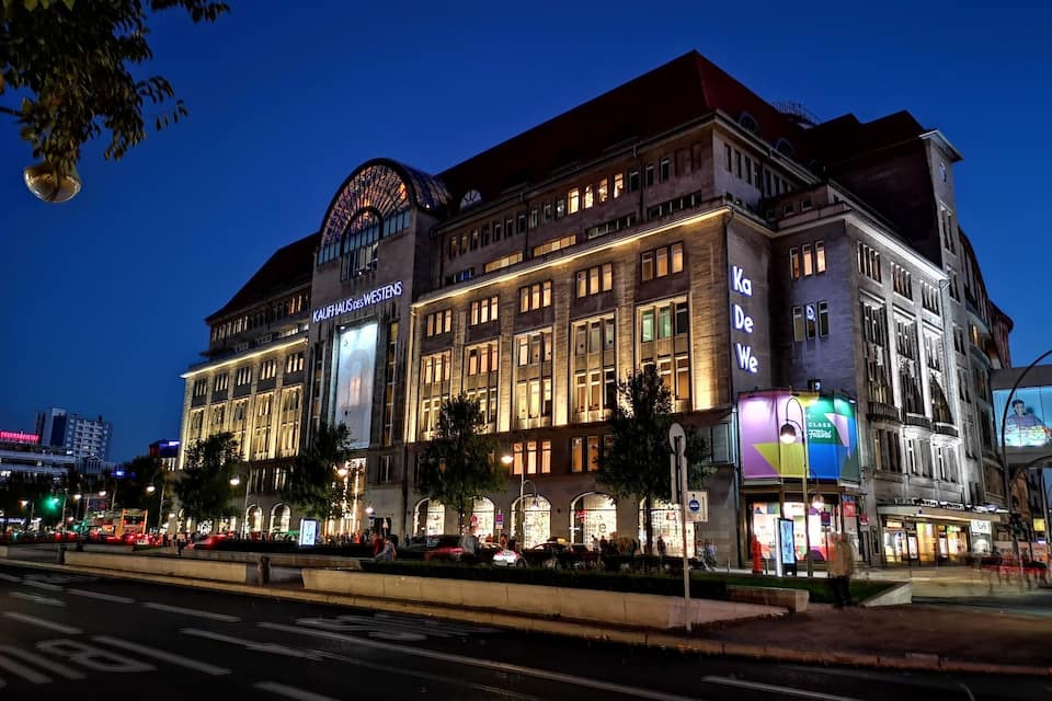 A historic building with illuminated signage, including "Kaufhaus des Westens" and "Ka De We."