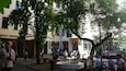 A public square with trees, benches, and people.