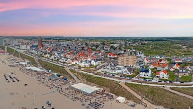 Uma vila costeira com praia, edifícios e uma torre.