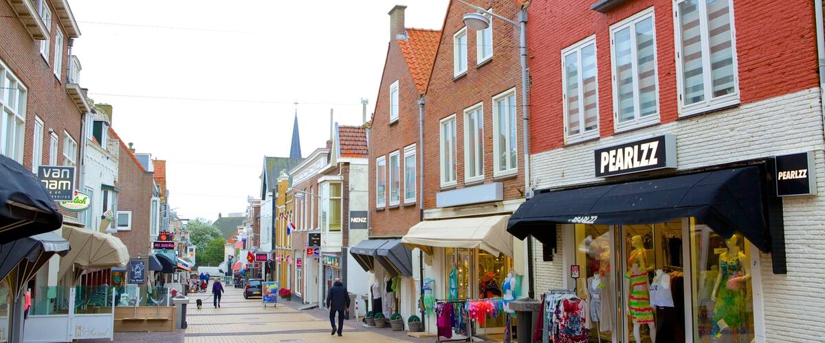 A street with shops, including a pharmacy and a clothing store.