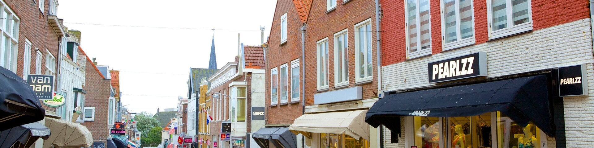 A street with shops, including a pharmacy and a clothing store.