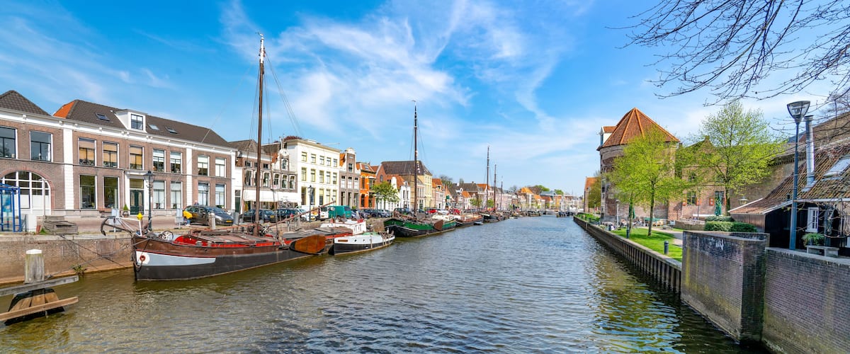 A canal lined with historic buildings and boats docked along the water.