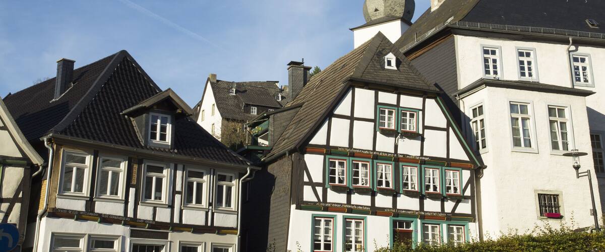 A traditional European town with half-timbered houses and a church with a spire.