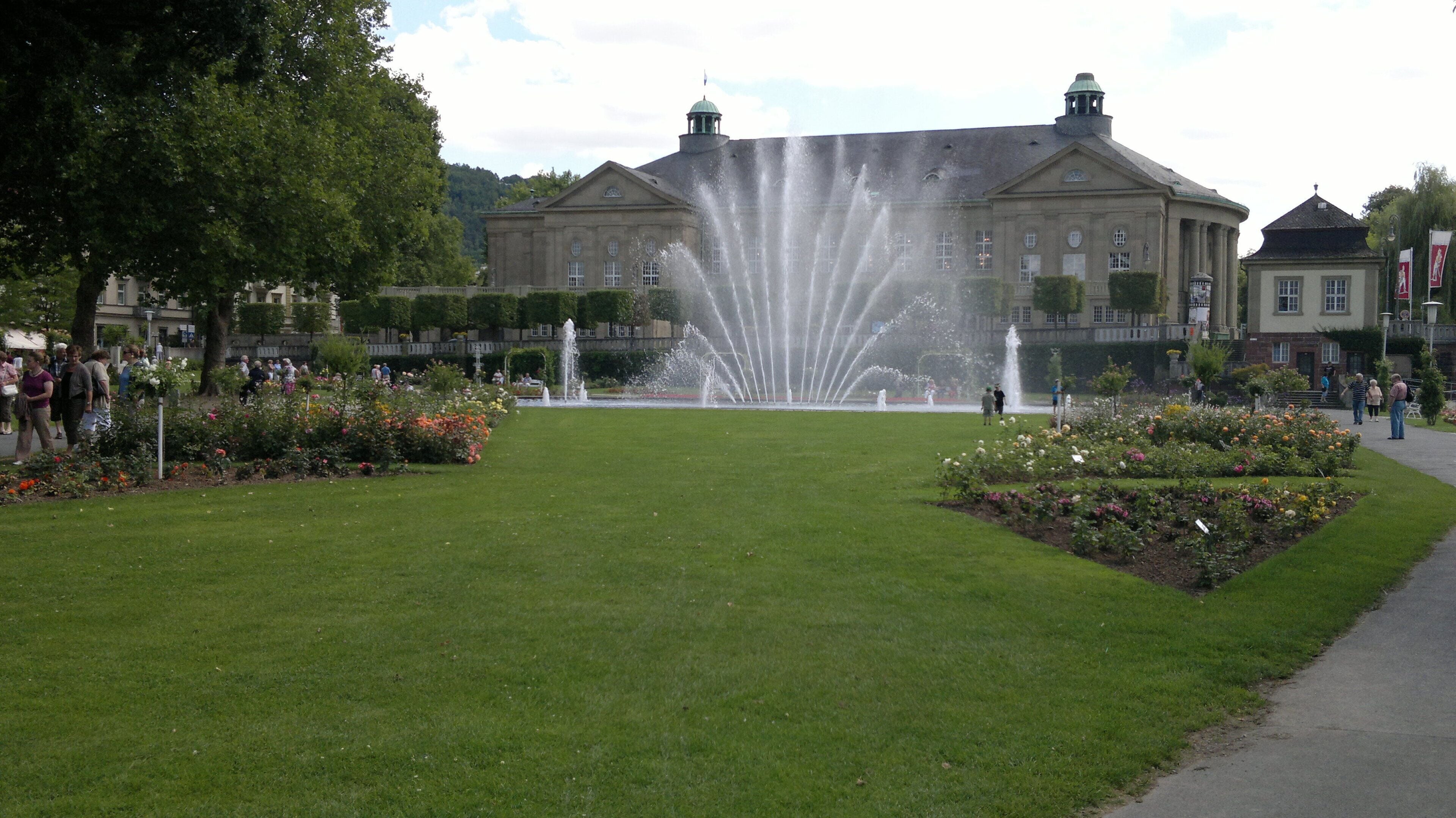A large building with a fountain in front.