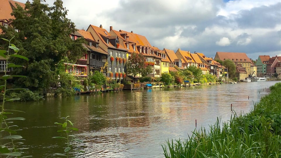 Une rivière bordée de bâtiments traditionnels.