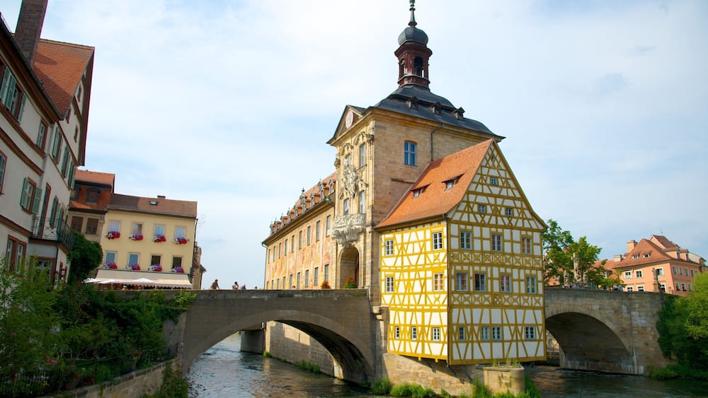 Ein historisches Gebäude mit einem Turm und einer Brücke über einem Fluss.