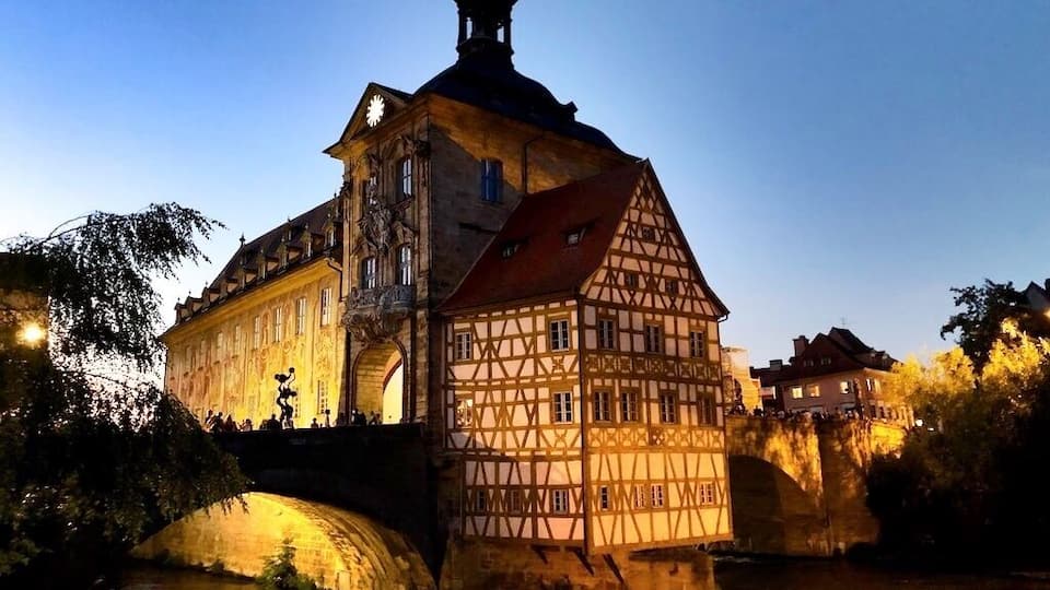 Un bâtiment historique doté d’une tour imposante, avec une rivière en premier plan.