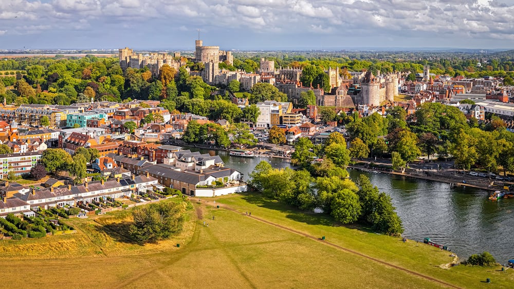 A historic city with a castle, river, and surrounding greenery.