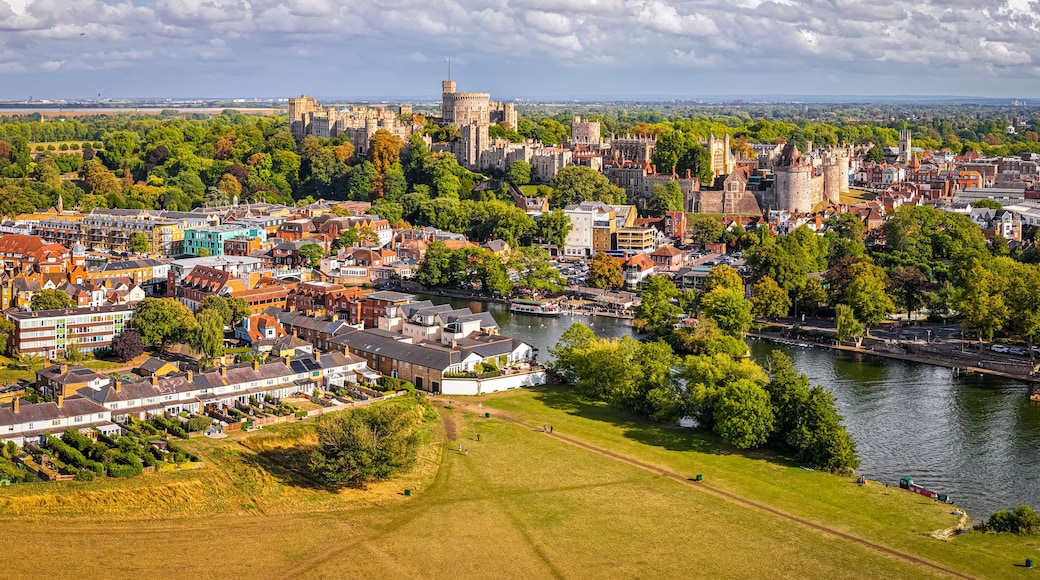 Aerial view of Windsor Castle surrounded by town buildings and lush green landscape