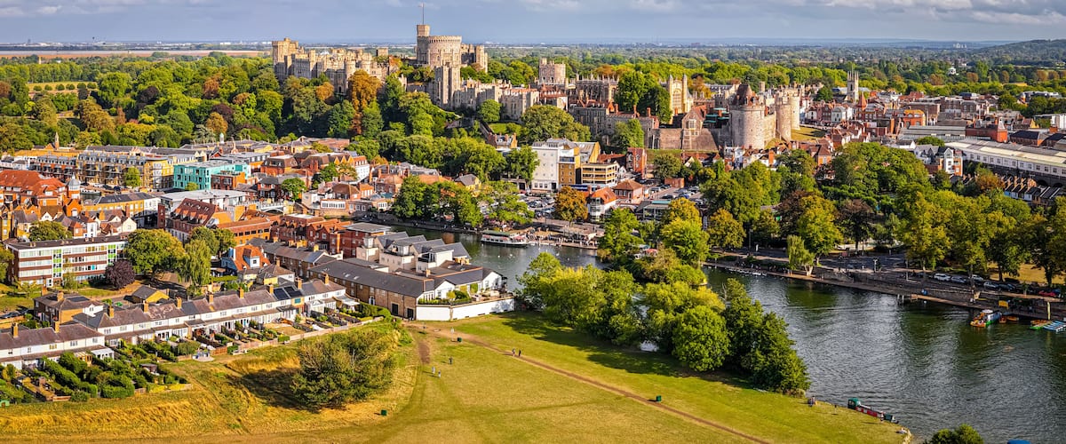 Eine historische Stadt mit Burg, Fluss und umgebender Natur.
