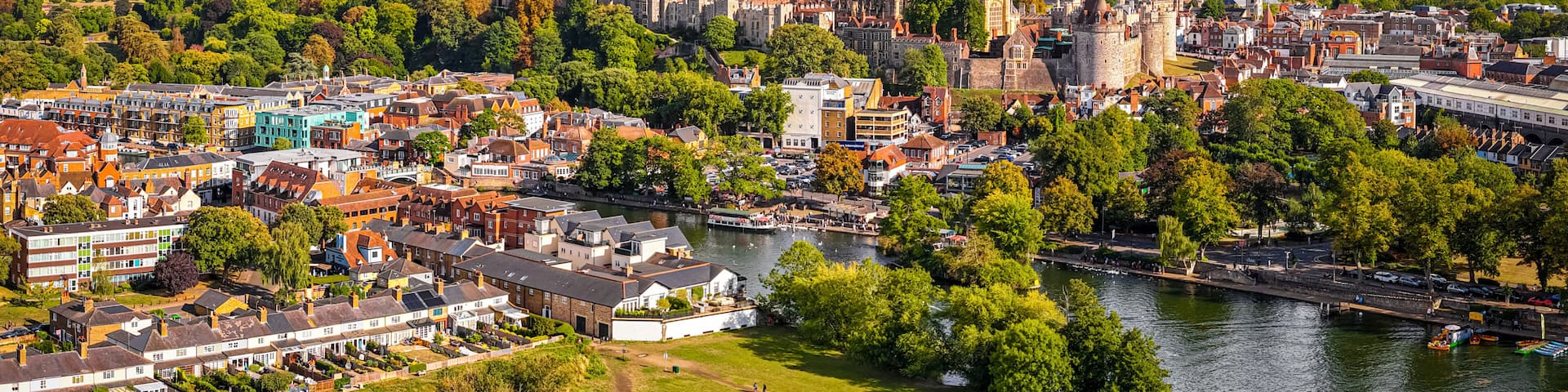 A historic city with a castle, river, and surrounding greenery.