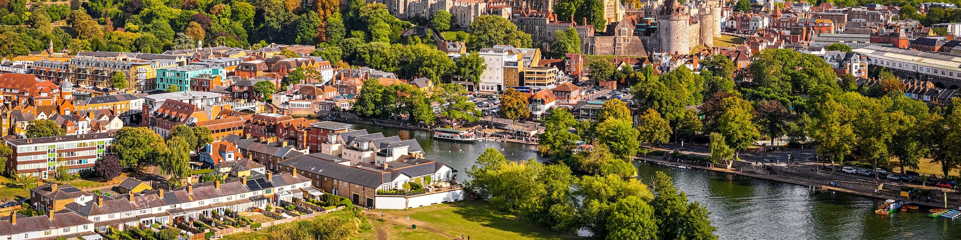 Aerial view of Windsor Castle surrounded by town buildings and lush green landscape