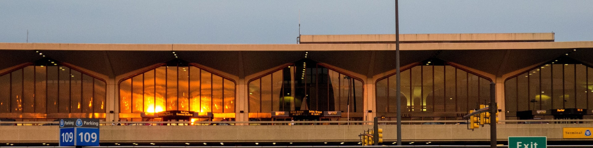 sunset orange light reflecting on windows of terminal building in Newark Airport