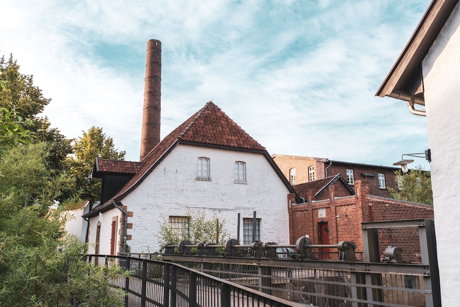 Historic Tuchmacher Museum Bramsche with Brick Chimney, White Mill Building and Industrial Heritage Architecture
