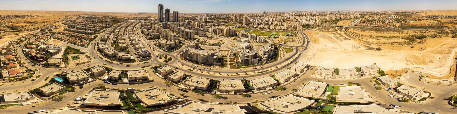 A cityscape with a central roundabout, surrounding residential areas, and distant desert landscape.
