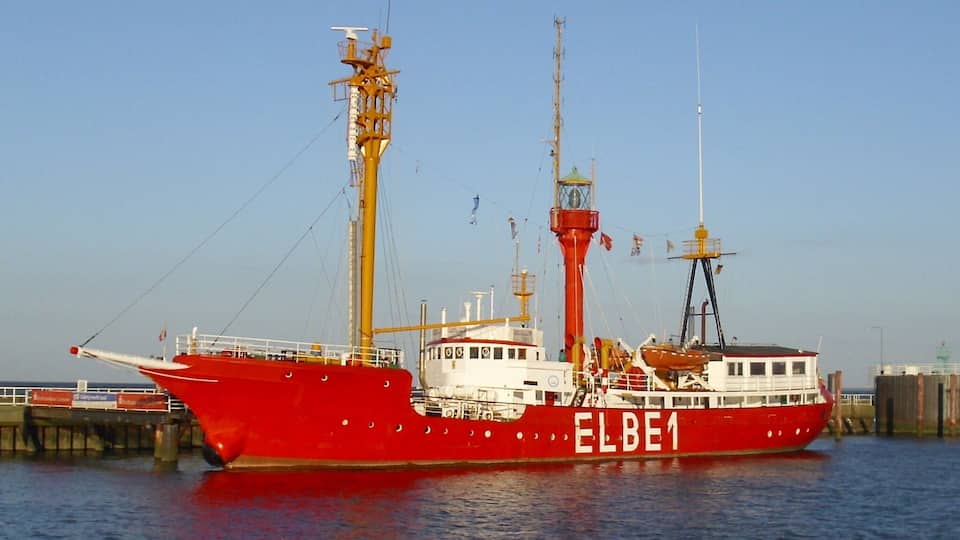 A large red ship named ELBE1 docked at a pier.