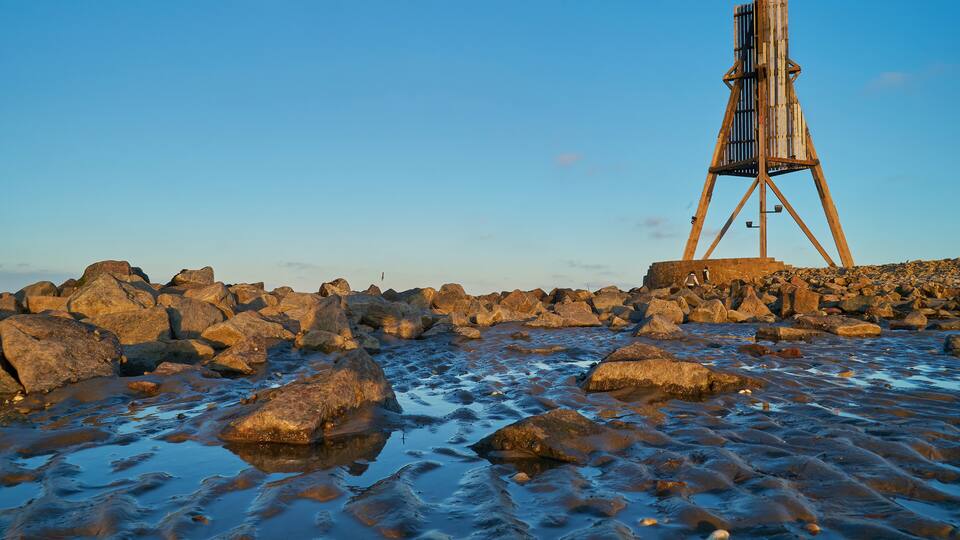A rocky shoreline with a wooden structure.