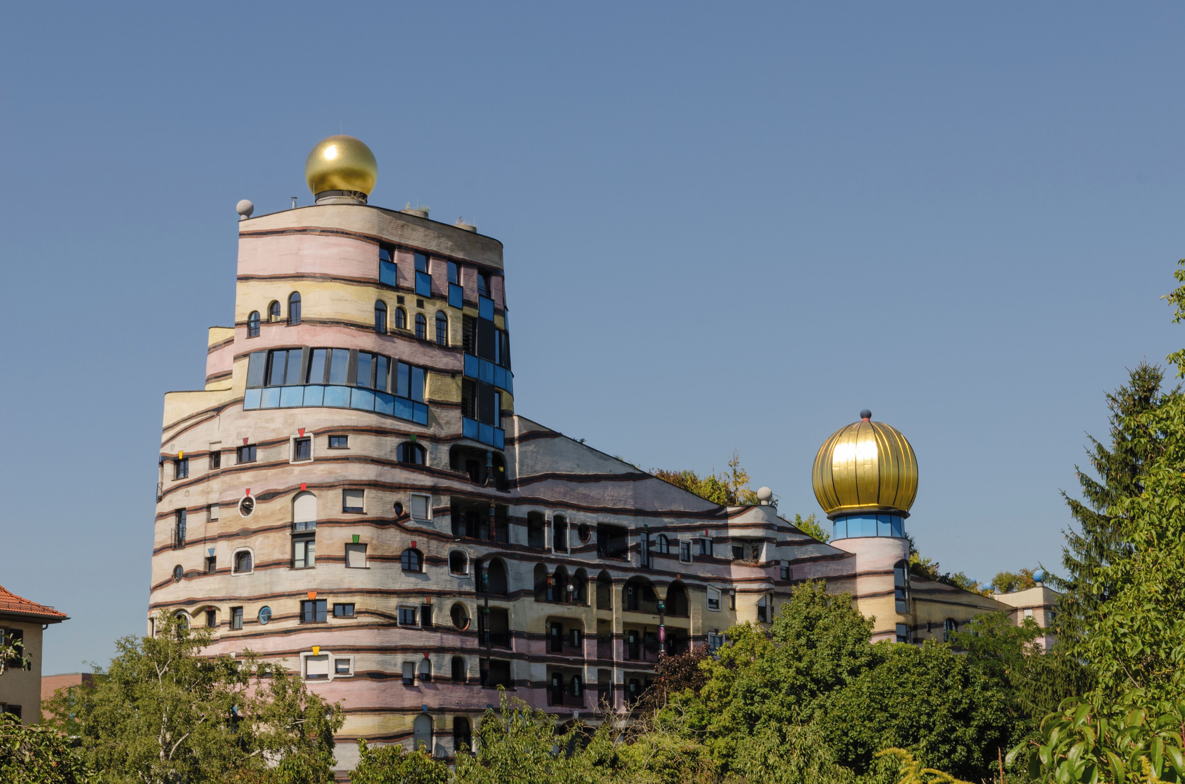 A uniquely designed building with multiple levels and golden domes.