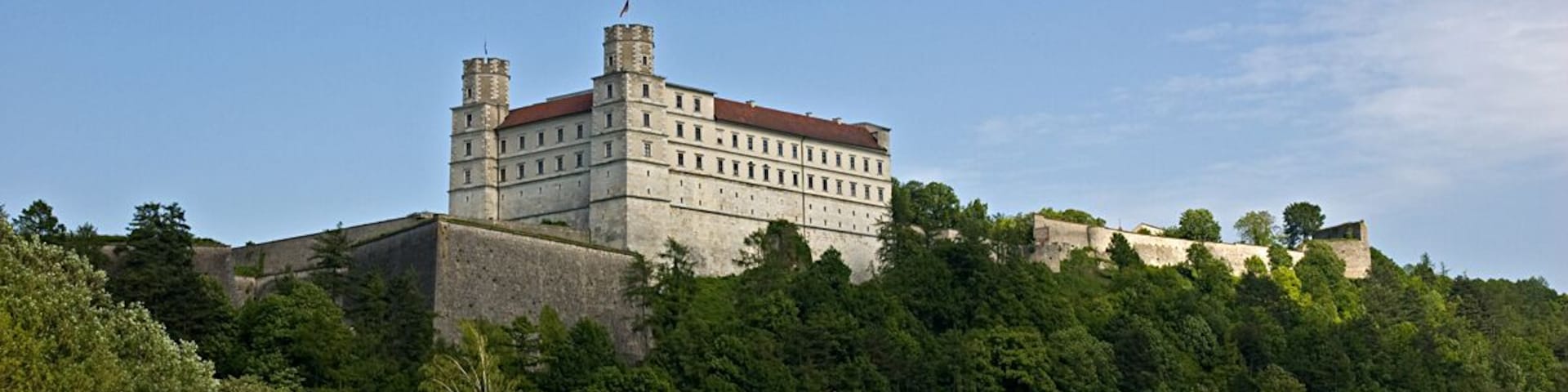 Eichstätt - Willibaldsburg Die Willibaldsburg ist eine um 1353 errichtete Burganlage in Eichstätt im Regierungsbezirk Oberbayern. Sie war bis ins 18. Jahrhundert repräsentative Burg und Residenz der Eichstätter Bischöfe. Eine erste Befestigungsanlage auf dem Burgberg wird bereits 1070 erwähnt. Unter Bischof Berthold von Zollern begann um 1355 der Ausbau zur wehrhaften Residenz der Bischöfe von Eichstätt; der alte Bischofssitz lag in der Stadt neben dem Dom. Bischof Friedrich IV. von Oettingen (1383-1415) verstärkte die Befestigung durch die Anlage eines Zwingers und ließ ein "aestuarium magnum aestivale" errichten. Unter den Bischöfen Albrecht II. von Hohenrechberg (1429-1145) und Martin von Schaumberg (1560-1590) wurde die Burgveste erweitert und verstärkt. Unter Bischof Johann Konrad von Gemmingen (1595-1612) erhielt die Burg unter anderem einen botanischen Garten, den Hortus Eystettensis. Ebenfalls unter ihm begann ab 1609 der Bau eines repräsentativen Renaissanceschlosses nach italienischem Muster. Die Pläne hierzu lieferte der Augsburger Stadtbaumeister Elias Holl, dem Erbauer des Augsburger Rathauses. Dieses Fürstenschloss gilt auch in seiner reduzierten Form als eines der wichtigsten Werke der deutschen Renaissance. Die zweitürmige Fassade entstand ab 1629 unter Mitwirkung von Hans Alberthal und dessen Nachfolger Martin Barbieri. Bischof Johann Christoph von Westerstetten (1612-1636) vollendete den Neubau und veranlasste weitere Umbauten. Dennoch konnten die Schweden 1633 während des Dreißigjährigen Krieges die Schloßfestung einnehmen. Den katholischen Truppen gelang anschließend allerdings die Rückeroberung und erfolgreiche Verteidigung. Bischof Marquard II. Schenk von Castell (1636-1685) ordnete die Beseitigung der Beschädigungen an und ließ Geschützkasematten in die Bastionen einbauen. 1725 verlegten die Bischöfe die Residenz in das neue Stadtschloss am Dom. Seit 1880 war die Stadt Eichstätt in Besitz der Burg. 1900 wurde sie vom bayerischen Staat erworben und unter Denkmalschutz gestellt. Um 1900 setzten erste Bemühungen zur Erhaltung der Substanz ein. 1962 übernahm die Bayerische Verwaltung der staatlichen Schlösser, Gärten und Seen die Willibaldsburg und umfangreiche Sanierungsmaßnahmen begannen. 1976 konnte das Jura-Museum im Gemmingenbau eröffnet werden. 1980 wurde das Museum für Vor- und Frühgeschichte der Öffentlichkeit übergeben und 1998 wurde der rekonstruierte Bastionsgarten eingeweiht. Nach 2000 legte man einen Rundweg um die Gesamtanlage an und beseitigte den Schutt vor den beiden Hauptbastionen, so dass das Befestigungskonzept heute vollständig erlebbar geworden ist. (aus Wikipedia) de.wikipedia.org/wiki/Willibaldsburg www.eichstaett.info/sehenswertes/willibaldsburg.htm de.wikipedia.org/w/index.php?title=Datei:De_Merian_Franko... Daten zur Geschichte der Willibaldsburg www.histver.de/dkmt/willibald.htm