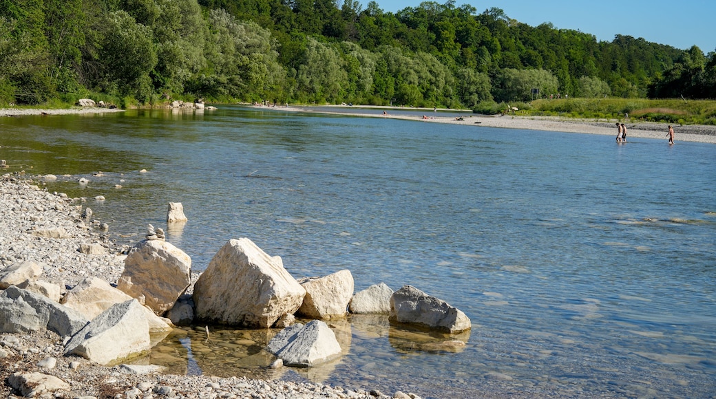 Ein Fluss mit klarem Wasser, umgeben von felsigen Ufern und dichtem Grünwald.
