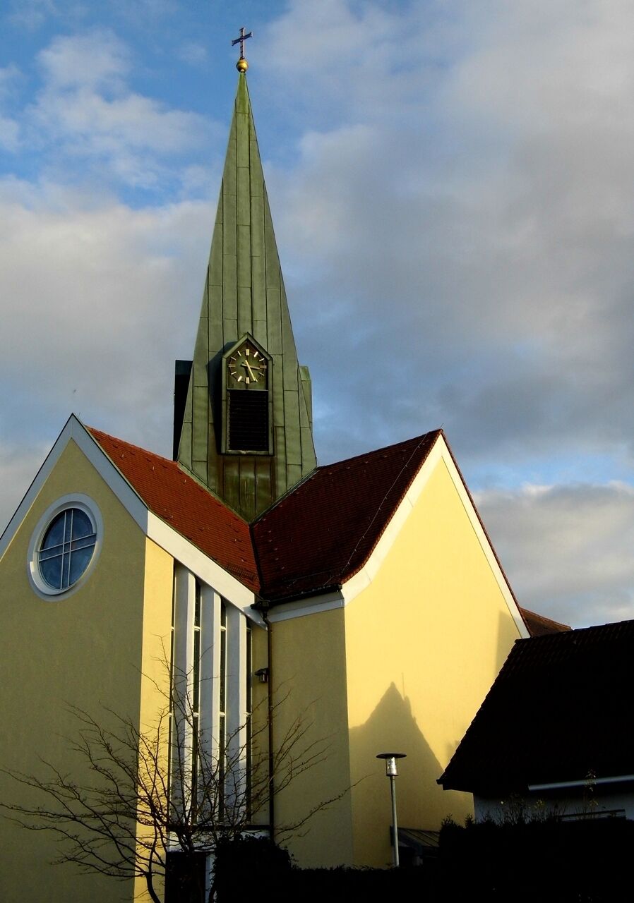 A church with a green spire and a clock.